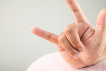 Hand with sign of Love on pink fluffy pillow. Valentine's day concept. Extreme close up shot. Copy space.