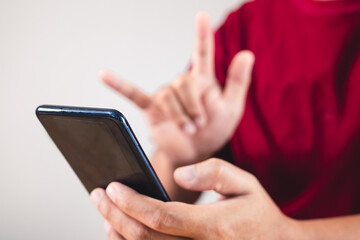 Valentine's day concept. Person uses hand to give love thru a smartphone. This shot focused on mobile.