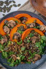 Salad with baked pumpkin, lentils on a table