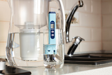 Measurement of TDS of water. Electronic pH meter in a glass of water.Filter for water purification....