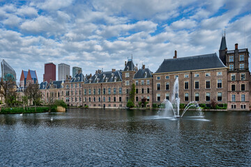 View of the Binnenhof House of Parliament and the Hofvijver lake with downtown skyscrapers in background. The Hague, Netherlands