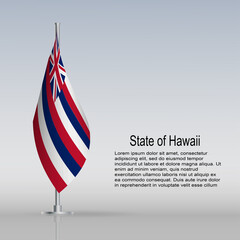 Flag of State of Hawaii (USA) hanging on a flagpole stands on the table.