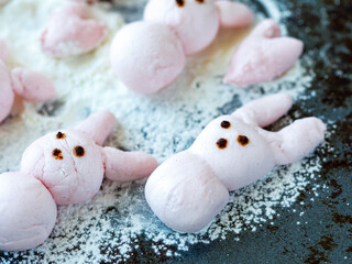 Cute pink marshmallow peeps bunny on baking tray. Cooking funny food with cartoon character. Handmade easter pastry concept. Close up