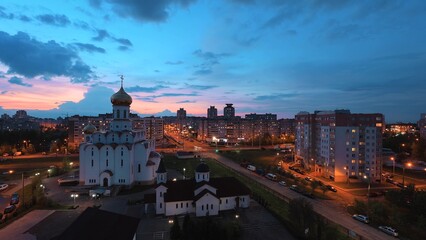 Change Day To Night Transition Traffic On Street And Multi-storey Residential Houses. Cityscape Minsk Skyline With Russian Orthodox Church. 4K Cloudy Sky With Clouds In Motion Above Multi-storey