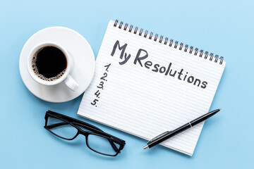 Resolutions hand writing list in notepad - inspirational and motivating concept
