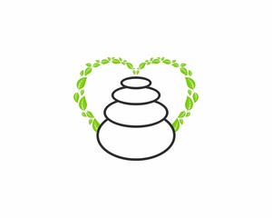 Zen stone balancing with green leaf behind