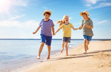 Cute children running along the sea coast