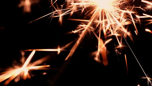 Beautiful and simple burning of a sparkler close-up on a dark background