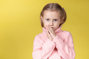 Begging little caucasian elementary age school girl looking at the camera