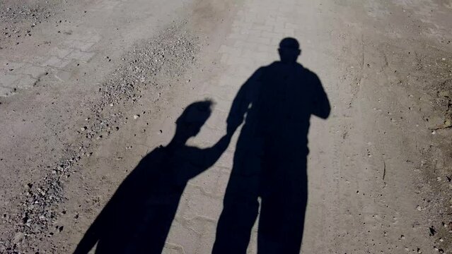 two human shadows, human figures walking on the road,