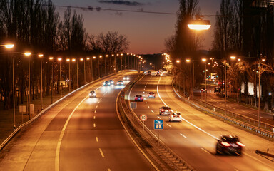 Fototapeta na wymiar fahrende autos auf doppelspuriger strasse bei nacht