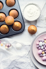 Process of preparation glazed Easter cupcakes decorated with mini chocolate eggs candy