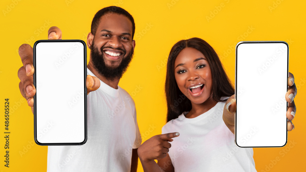 Poster black couple showing two blank empty smartphones screen for mockup