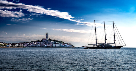 Fototapeta na wymiar Big Sailboat Anchors In Front Of Historic City Of Rovinj In Croatia