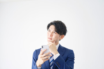 ビジネスマン　スマホ　考える　白背景