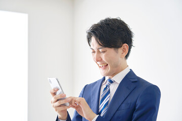 ビジネスマン　スマホ　笑顔　白背景