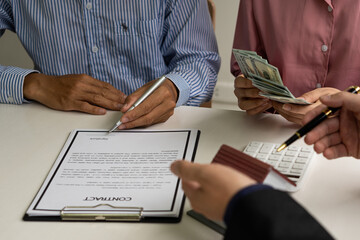 The real estate agent or bank officer explains the interest on the loan to the customer with a home loan agreement to his client after signing the contract. real estate concept