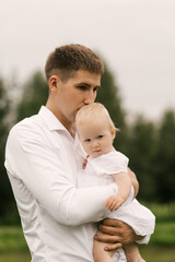 Fototapeta premium Beautiful young family, dad playing with one-year-old daughter in nature