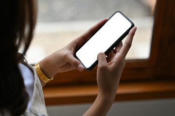 Closed up with young  woman hand using a touch screen smartphone with blank white screen. for technology and business concept.