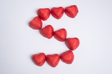 Chocolate red heart sweets in the shape of the letter S for Valentine's Day on a white background