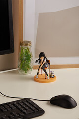 Detail shot of a figurine of a brunette girl in a school uniform sitting in a chair. The statuette...