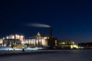 Fototapeta na wymiar Sundsvall, Sweden A view of a paper mill at night on a frozen bay of Sundsvall.
