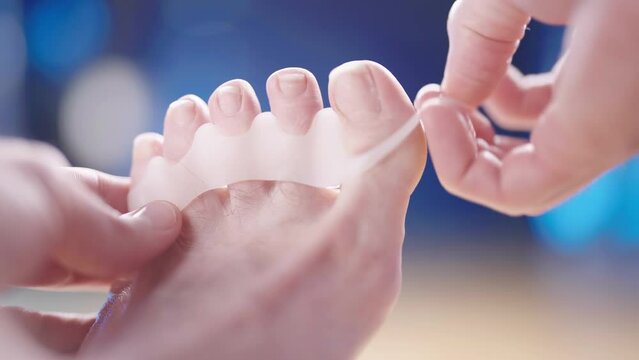 Remove medical silicone toe corrector spreader between toes close-up 4K