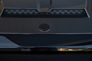 air intake on the hood of an expensive SUV, carbon fiber trim, glossy black surfaces, very expensive