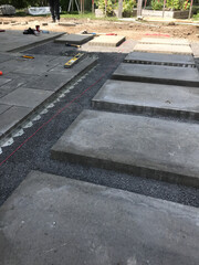 Travaux d'aménagement paysager, pose de grandes dalles de béton dans les cours arrière, chantier de construction