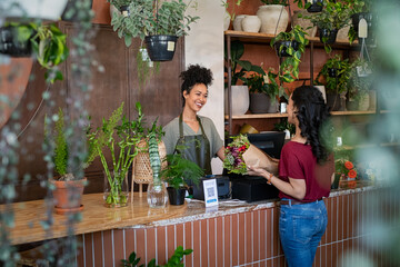 Happy florist selling plants and flower to client - Powered by Adobe