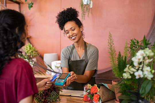 Customer paying with contactless credit card at flower shop