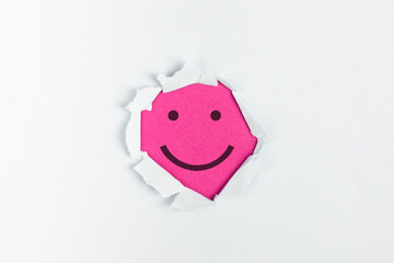 Smiling happy face under a torn paper, positive emotions, good customer feedback, laughing