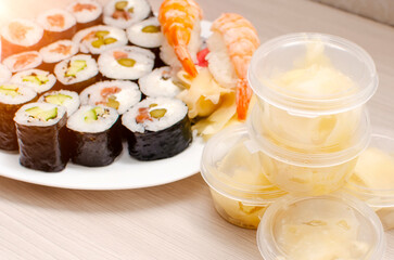 Pickled white ginger next to a set of rolls. Japanese food, closeup, selective focus.
