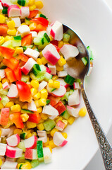 cucumbers, corn and bell pepper salad in white bowl. Top view, copy space. Vertical photography.