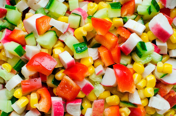 Chopped vegetables: cucumbers, bell peppers, corn for salad preparation.