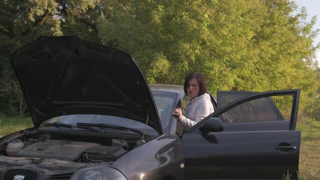 Women push the broken car on the road.