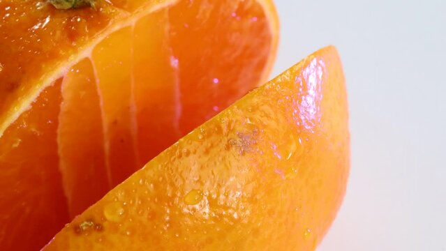 Very sharp knife cutting a thic slice of tangerine. Chopping, slicing, close up macro shot.