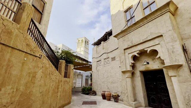 Old Residential Buildings With Traditional Wind Tower Along Narrow Alley In Al Fahidi Historical District In Dubai, UAE. panning left