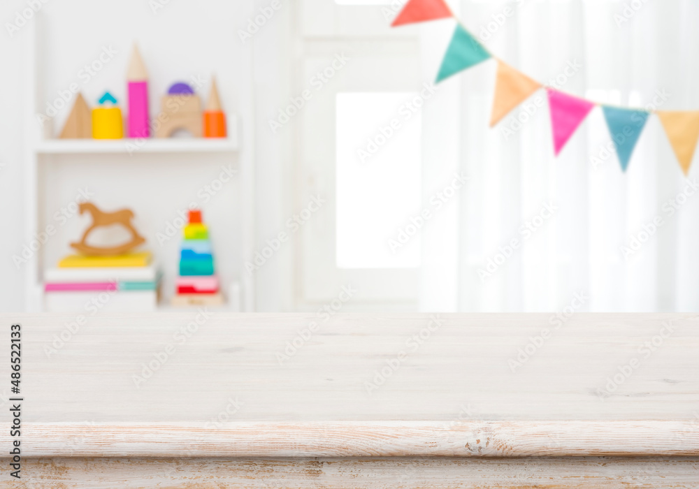 Wall mural empty table with blurred children toy shelf and window background