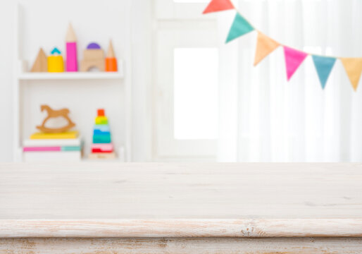 Empty table with blurred children toy shelf and window background
