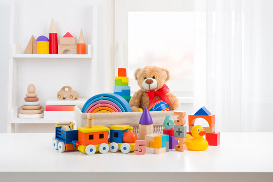 Various cute toys collection on wooden table in children room