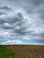 plowed field in spring under a picturesque dark sky clouds before the storm in the spring