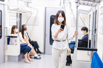 マスクをして電車にのる女性