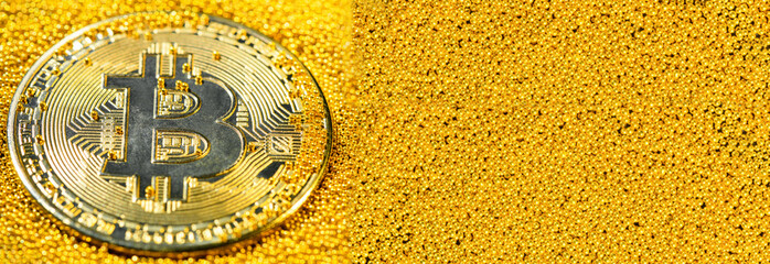 Golden bitcoin on yellow gold placer surface. Crypto currency. Bitcoin mining concept. Banner
