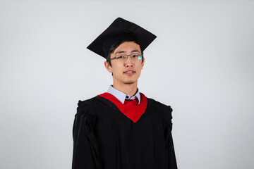 Graduate in glasses wearing gown and mortarboard on a white background