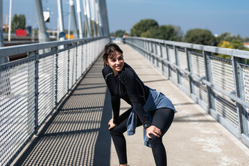 Young active sporty business woman morning routine of stretching and running exercising outdoor...