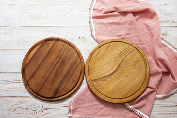 two empty wooden pizza trays on the tablecloth on the table top view