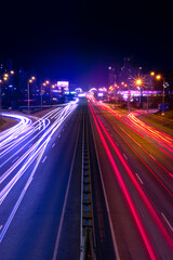 Fototapeta na wymiar Night city traffic. Light trails from cars moving along the road. Light trails from fast moving cars at night