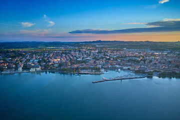 Fototapeta premium Top view of the boat parking on the lake. Italian resorts on Lake Garda. Aerial view of Desenzano del Garda. Aerial panorama of the town of Desenzano del Garda on Lake Garda in Italy.
