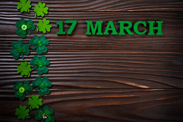 Handmade Shamrock leaves on dark wooden background with copy-space flat lay view